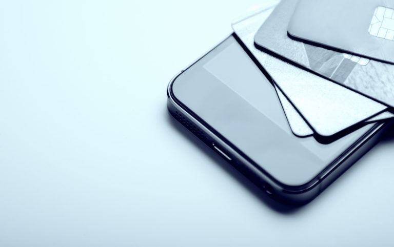 E-commerce. Credit cards on a phone. Online payment, shopping from home. Creative processing. copy space